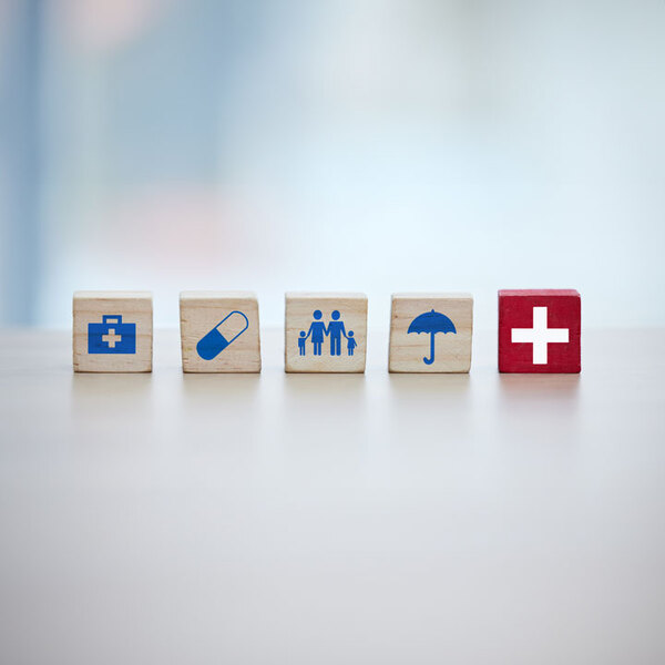 Healthcare, insurance and wooden blocks in studio on an empty gray background for safety or security. Abstract, medicine and health with block toys in a hospital or clinic for medical care