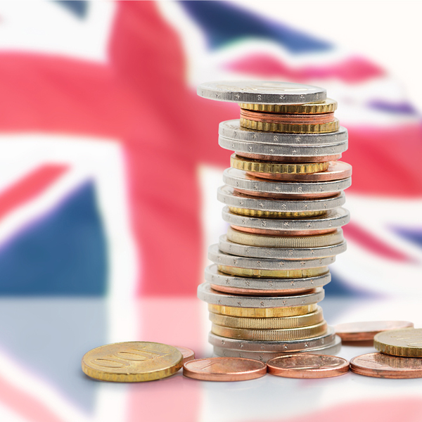 Coins stacked with United kingdom flag in background