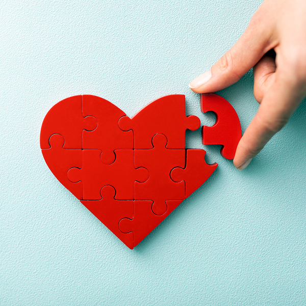 A woman arranges red heart shape puzzles