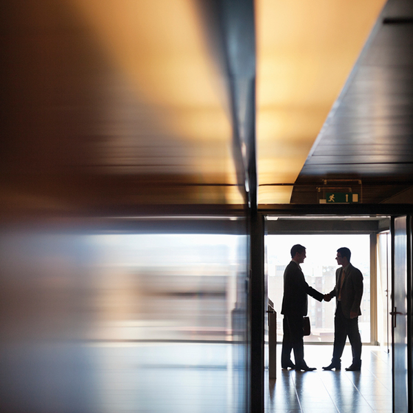 Businessman shaking hands together in corridor