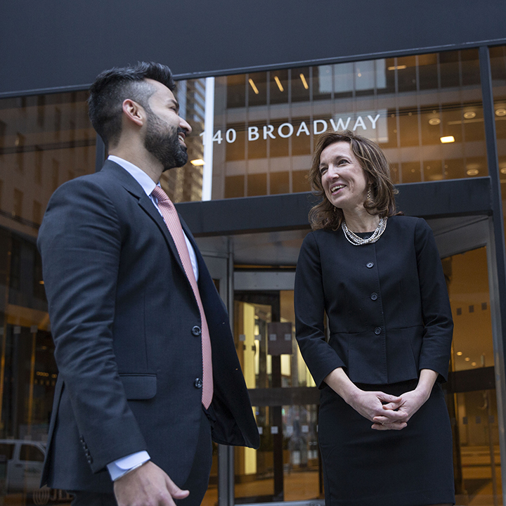 2 BBH'ers standing outside of NY office entrance having a work discussion