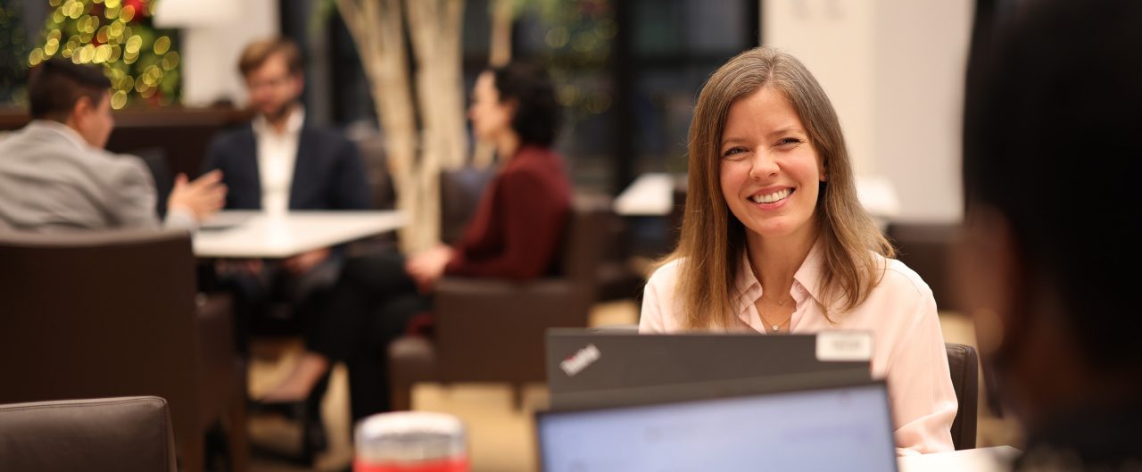 Woman sitting at table smiling at a colleague