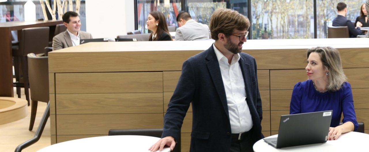 Man and woman talking at table in open area 