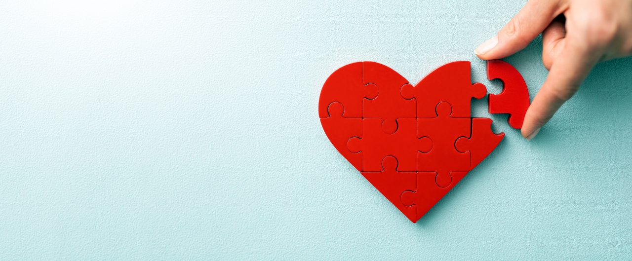 A woman arranges red heart shape puzzles