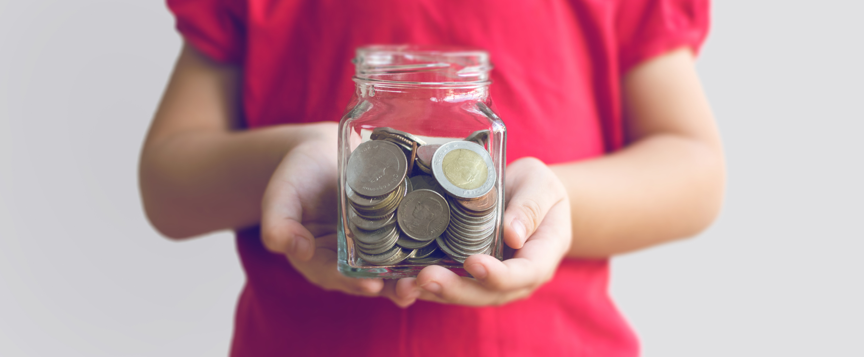 Child holding a jar of coins